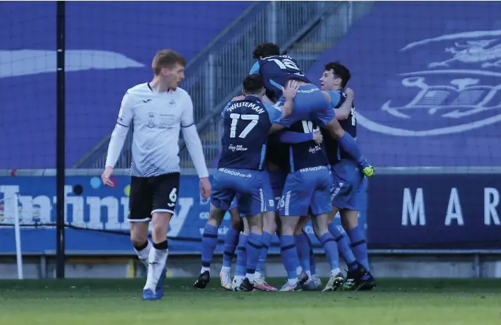  ?? Gareth Everett/huw Evans Agency ?? Former Swans star Scott Sinclair is mobbed by his Preston team-mates after setting up Matt Grimes’s injury-time own goal at the Liberty Stadium yesterday.