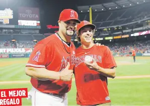  ??  ?? EL MEJOR REGALO El dominicano de los Angelinos, Albert Pujols, posa con Scotty Steffel, luego de que el fanático le entregara la pelota del histórico jonrón 600, tras el partido del sábado ante los Mellizos de Minnesota.