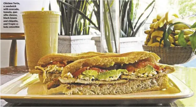  ??  ?? Chicken Torta, a sandwich with avocado, tomato, quesillo cheese, black beans and chipotle, and Tropic-olada smoothie