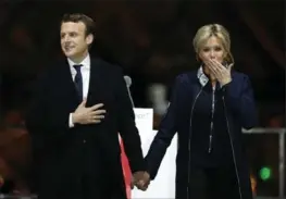  ?? THIBAULT CAMUS, THE ASSOCIATED PRESS ?? French president-elect Emmanuel Macron holds hands with his wife, Brigitte, during a victory celebratio­n Sunday outside the Louvre museum in Paris.