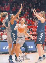  ?? JIM THOMPSON/JOURNAL ?? UNM’s Cherise Beynon drives between Utah State’s Antonia Robinson (41) and Shannon Dufficy (5) on Wednesday. Beynon was just 7-of-19 from the floor but had 23 points and eight assists.