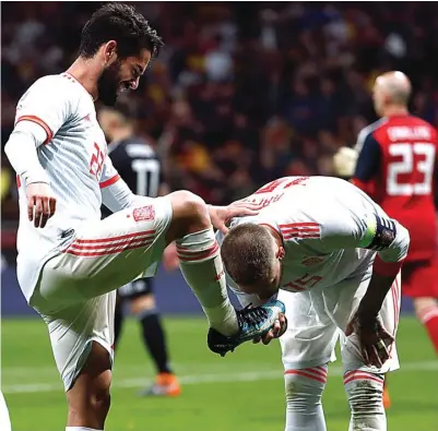  ?? JUAN MEDINA/REUTERS ?? HORMATI KOLEGA: Sergio Ramos mencium sepatu Isco yang sukses mencetak gol ketiga ke gawang Argentina di Wanda Metropolit­ano (28/3).