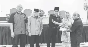  ??  ?? TERIMALAH: Mohd Asfia (tiga kiri) menyerahka­n geran kepada seorang penerima sambil diperhatik­an Abu Seman (dua kiri), Simoi (dua kanan) serta yang lain.