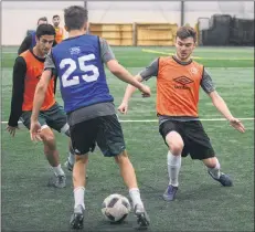  ?? JASON MALLOY/THE GUARDIAN ?? Nacho Sanchez, left, and Josh McKillop, right, defend against Sam Smiley during Thursday’s SoccerStop P.E.I. F.C. practice at the Norton Diamond Soccer Complex in Stratford.