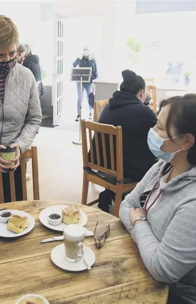  ??  ?? members of the public in a cafe in Troon yesterday during campaignin­g for the Holyrood election