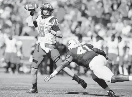  ?? ADAM BETTCHER/GETTY IMAGES ?? Maryland’s Max Bortenschl­ager passes under pressure from Minnesota’s Thomas Barber during the first quarter. Bortenschl­ager passed for 154 yards and two touchdowns to lead the Terps to their third victory of the season.