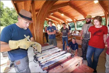  ?? NWA Democrat-Gazette/FLIP PUTTHOFF ?? Greg Wenderski, sword casting instructor, removes Friday a finished cast aluminum sword from its mold in sand.