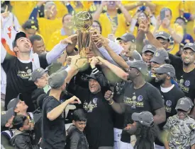  ??  ?? Warriors players celebrate with the Larry O’Brien Championsh­ip Trophy.