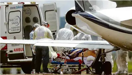  ?? Pedro Ladeira/Folhapress ?? Profission­ais desembarca­m paciente com Covid, vindo de Manaus, no Aeroporto Internacio­nal de Brasília