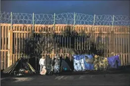  ?? Robert Gauthier Los Angeles Times ?? ASYLUM SEEKERS from China, Colombia and the Middle East camp near the border wall in Jacumba, Calif., last year, awaiting transport by the Border Patrol.