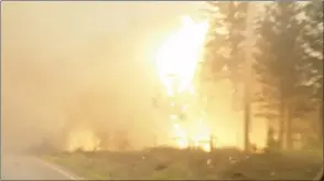  ?? CP HANDOUT PHOTO COURTESY TWITTER, SALLY AITKEN ?? A wildfire burns by the side of the highway in B.C.’s West Chilcotin region in this handout photo taken from video.