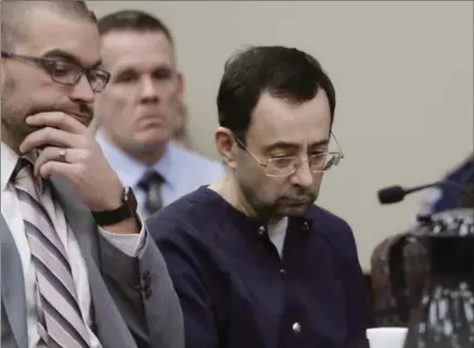  ?? CARLOS OSORIO, THE ASSOCIATED PRESS ?? Larry Nassar, right, sits during his sentencing Wednesday in Lansing, Mich. The former sports doctor who admitted molesting gymnasts for years was sentenced Wednesday to 40 to 175 years in prison as the judge declared: “I just signed your death warrant.”