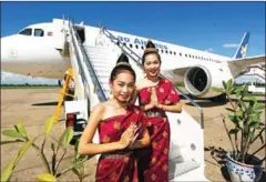  ?? SAEED KHAN/AFP ?? Two Laos hostesses greet in a traditiona­l way after the induction of Lao Airlines’ first Airbus A320 in Vientiane in 2003.