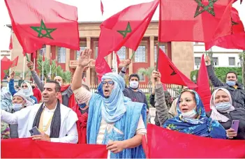  ?? — AFP photo ?? Moroccans celebrate in front of the parliament building in Rabat after the US adopted a new official map of Morocco that includes the disputed territory of Western Sahara.