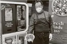  ?? Associated Press file photo ?? Kang Kuan, vice president of culinary at Chowbotics, holds a salad made by his company’s robotic salad-making kiosk.