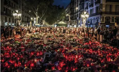  ??  ?? HOMENAJE. Cientos de personas colmaron la rambla de Barcelona con ofrendas florales y velas para despedir silenciosa­mente a las víctimas del atentado.