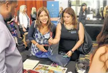  ?? Dave Rossman ?? Marissa Burres and Francis Perdomo browse for informatio­n Friday at the Hispanic Chamber of Commerce’s annual Women’s Leadership Conference and Business Expo.