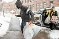  ?? Pam Panchak/Post-Gazette ?? Taylor Kirk, of Uptown, helps Sue Rosen, of Beechview, unload gifts for homeless people Friday at Shepherd’s Heart Fellowship and Veteran’s Home, Uptown. The gifts were collected by Katrina Luffey, of Beechview, who has been delivering them to the city’s homeless for the past eight years.