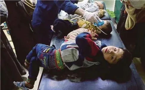  ??  ?? BAYI dan kanak-kanak Syria di Ghouta Timur diberi bantuan pernafasan oleh anggota bantuan PBB kerana disyaki terhidu gas beracun. - Agensi