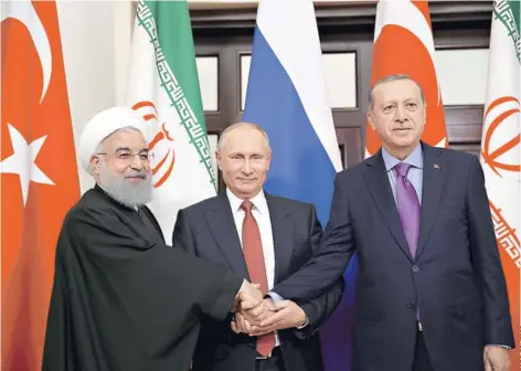  ??  ?? ► El Presidente de Irán, Rohani, el mandatario ruso, Putin y su par turco, Erdogan se saludan ayer en Sochi.