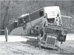  ?? Josh Briggs/Saline Courier via AP ?? ■ Employees from a wrecker service work to remove a charter bus from a roadside ditch Monday after it crashed alongside Interstate 30 near Benton, Ark. The bus was carrying a youth football team from Tennessee when it rolled off an interstate off-ramp and overturned before sunrise Monday. The elementary-school-age football team from Orange Mound Youth Associatio­n in southeast Memphis had played in a tournament in Dallas over the weekend.