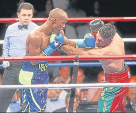  ?? JOHN HAEGER @ONEIDAPHOT­O ON TWITTER – ONEIDA DAILY DISPATCH ?? Argenis Mendez, left, and Arash Usmanee exchange blows in their IBF Junior Lightweigh­t Championsh­ip bout on Friday which ended in a draw.
