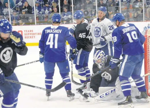  ?? JOE GIBBONS/THE TELEGRAM ?? Toronto Maple Leafs netminder Michael Hutchinson pounces on a loose puck as teammates Dmytro Timashov (41), Teemu Kivihalmie (45), Nick Shore (26) and Andreas Johnsson (18) look on during a scrimmage Friday morning at the Paradise Double Ice Complex on the first day of the Leafs’ training camp.