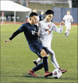  ?? SUZANNE TENNANT/POST-TRIBUNE ?? Bishop Noll’s Bruno Zamora, left, attempts to tip the ball away from Indianapol­is Ritter’s Ryan Hofer during the Class 2A state championsh­ip game on Friday.