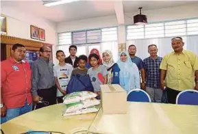  ?? [FOTO ZULKARNAIN AHMAD TAJUDDIN/BH] ?? Keluarga Farah Marcella bersama wakil agensi yang menyalurka­n sumbangan di SMK Seri Kota Puteri, Johor Bahru, semalam.