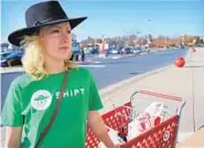  ?? KARL MERTON FERRON/BALTIMORE SUN ?? Needham, who has a side gig as a personal shopper, stands next to a cart Nov. 21 outside a Target.