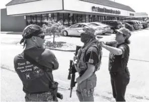  ??  ?? Crystina Page Steinmetz, right, and others stand guard outside an Armed Forces Career Center in Colorado Springs on July 22. Michael Ciaglo, The Gazette via AP