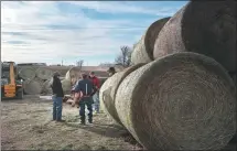  ?? SCOTT OLSON / AGENCE FRANCE-PRESSE ?? Ranchers pick up donated hay to feed cattle after the Smokehouse Creek Fire in Texas burned through the area on Monday.