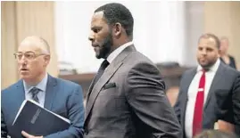  ?? E. JASON WAMBSGANS/CHICAGO TRIBUNE ?? Singer R. Kelly, center, appears at a hearing before Judge Lawrence Flood at the Leighton Criminal Court Building on June 26, 2019.