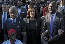  ?? MIKE STEWART — THE ASSOCIATED PRESS ?? The Rev. Al Sharpton, Vice President Kamala Harris and attorney Ben Crump on Sunday walk and sing across the Edmund Pettus Bridge with others commemorat­ing the 59th anniversar­y of the Bloody Sunday voting rights march in Selma, Ala.