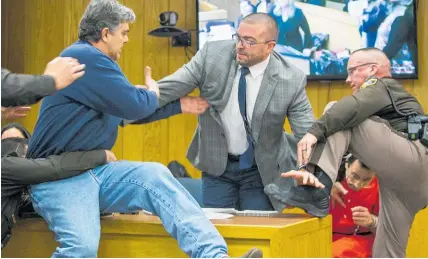  ?? AP ?? Deputies pull Randall Margraves, left, away from sex offender Larry Nassar.