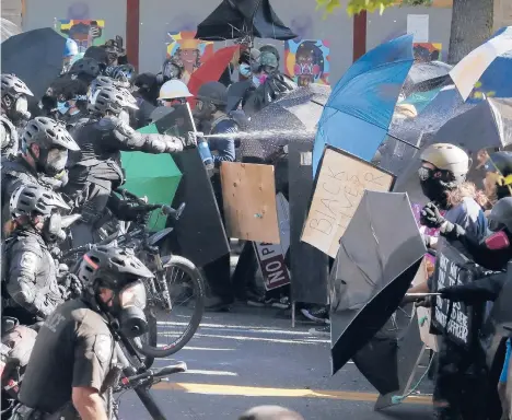  ?? TED S. WARREN/AP ?? Some legislatur­es addressed police use of force against Black people and others of color after the killing of George Floyd led to widespread protests. Above, police pepper spray Black Lives Matter protesters May 26 in Seattle.