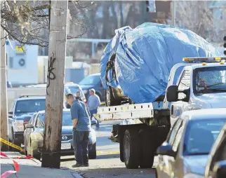  ?? HERALD PHOTO BY JOSEPH PREZIOSO ?? ‘NOT A RANDOM ACT’: Police remove a vehicle from Evans Street in Dorchester after a shooting left a man dead. Police Commission­er William B. Evans said the shooting was ‘targeted to the vehicle.’