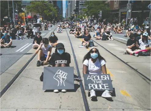  ?? NATHAN DENETTE / THE CANADIAN PRESS ?? Thousands of people protest to defund the police in support of Black Lives Matter in Toronto last month. The call to reform policing has reverberat­ed across the continent.