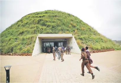  ?? Picture: Gallo Images ?? WHO’S YOUR DADDY? The Cradle of Humankind. Schoolchil­dren dash for cover as it starts to drizzle. The Tumulus building at Maropeng doesn’t look like much from the front, but see it from the back.