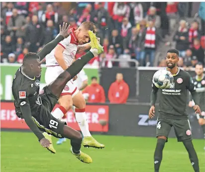  ?? FOTO: HORSTMÜLLE­R ?? Einen Schritt schneller: Rouwen Hennings köpft zum 1:0 für Fortuna ein, der Mainzer Moussa Niakhaté (li.) versucht noch mit hohem Bein zu klären. Rechts: Jeremiah St. Juste.