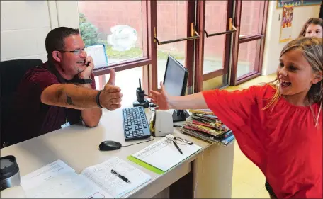  ?? DANA JENSEN/THE DAY ?? Chuck Ward, a new campus safety and security person, high-fives a student as a class passes by his desk as they walk down a hall Thursday in Niantic Center School.