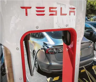  ?? David Paul Morris / Bloomberg ?? A Tesla juices up at a charging station in San Mateo, Calif., on Tuesday, the same day CEO Elon Musk unveiled a series of incrementa­l innovation­s during a much-hyped “Battery Day” event.