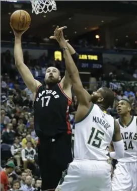  ?? MORRY GASH, THE ASSOCIATED PRESS ?? Raptors’ Jonas Valanciuna­s shoots against Milwaukee’s Greg Monroe during the first half of Game 6 of Thursday in Milwaukee. The Raptors won 92-89.