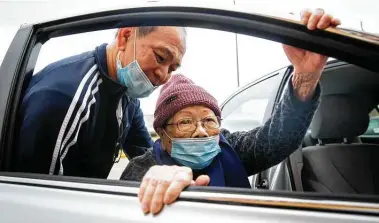  ?? Annie Mulligan / Contributo­r ?? Hiep Pham helps his mother, Hao Nguyen, back into their vehicle after receiving a COVID-19 vaccine at HOPE Clinic.