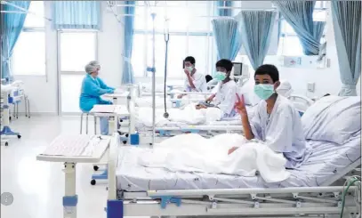  ??  ?? The Associated Press In this image made from video, released by the Thailand Government Spokesman Bureau, three of the 12 boys are seen recovering in their hospital beds after being rescued along with their coach from a flooded cave in Mae Sai, Thailand.