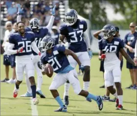  ?? MARK HUMPHREY — THE ASSOCIATED PRESS ?? In this file photo, Tennessee Titans defensive back Malcolm Butler (21) runs back onto the field after making an intercepti­on during NFL football training camp Saturday in Nashville, Tenn. Celebratin­g are fellow defensive players Logan Ryan (26),...