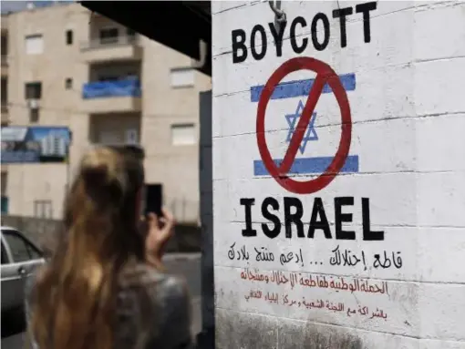  ?? (AFP/Getty) ?? A sign painted on a wall in Bethlehem calls for boycotts of Israeli products