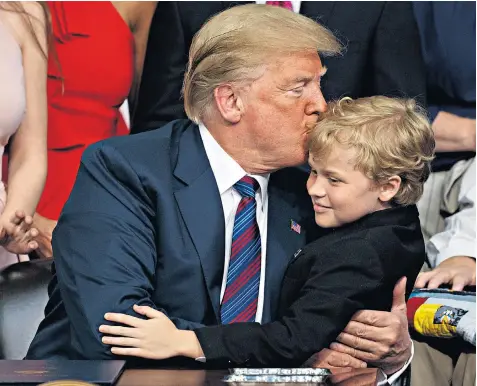  ??  ?? Donald Trump kisses Jordan Mclinn, a Muscular Dystrophy sufferer, at the White House, after signing the ‘Right to Try’ act, allowing terminally ill patients to try experiment­al drugs