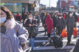  ?? CHANG W. LEE/NEW YORK TIMES ?? Some pedestrian­s wear masks in the Chinatown area of Queens, N.Y., last month. Americans should brace for the likelihood that the coronaviru­s will spread to communitie­s in the U.S., the Centers for Disease Control and Prevention warned Tuesday.