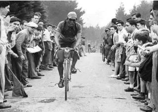  ??  ?? Fans watch on intently as Ruiz reaches the top of the Sollube climb on stage 12 of the 1948 Vuelta